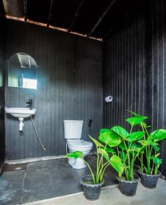 a bathroom with a toilet and a sink and plants at Father's Garden Inthanon in Ban Na Yang