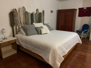 a bedroom with a large bed with a wooden headboard at El Castillo en el Lago Atitlán in San Marcos La Laguna