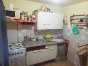a small kitchen with white cabinets and a stove at Chata Lužná u Hanušovic 