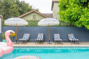 - un groupe de chaises longues et de parasols à côté de la piscine dans l'établissement Angel&Rose Universal Hollywood Heated Pool House King Bed, à Los Angeles