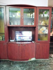 a wooden hutch with glass doors and a television in it at Joe Niwas villa 3bhk in Puducherry +10 photos