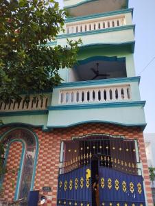a building with a blue door and a fence at Joe Niwas villa 3bhk in Puducherry