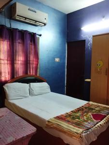 a bedroom with a bed and a blue wall at Joe Niwas villa 3bhk in Puducherry