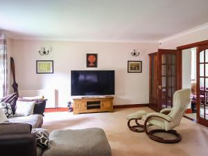 a living room with a couch and a television at Netherley Grange in Peterculter