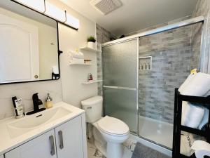 La salle de bains est pourvue de toilettes, d'une douche et d'un lavabo. dans l'établissement 2BR 1BA Guest Suite - Free Parking - Central Location w/ Mountain-View, à Vancouver
