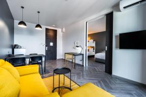 a living room with a yellow couch and a bedroom at Newly Opened - Blu Monkey Hub and Hotel Krabi Town in Krabi