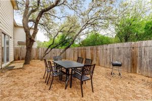 una mesa y sillas en un patio trasero con una valla en Golden Chest - Modern - UTSA Central - Fast WiFi, en San Antonio