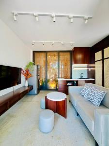 ein Wohnzimmer mit einer Couch und einem Tisch in der Unterkunft Boom Casa Homestay in Hue