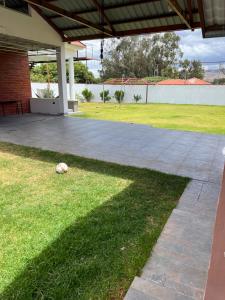 a soccer ball laying on the grass under a patio at Casa de Campo Guayllabamba in Quito