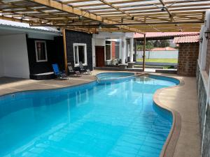 基多的住宿－Casa de Campo Guayllabamba，一个带凉棚的大型蓝色游泳池