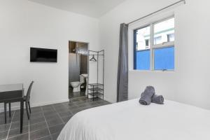 a bedroom with a bed and a desk and a window at Inn & Out Express Sea Point in Cape Town