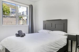 a bedroom with a large white bed and a window at Inn & Out Express Sea Point in Cape Town