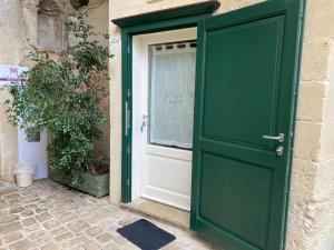 a green door of a house with a window at Residence Le Vie Del Mosto in Matera