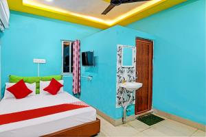 a blue room with a bed and a sink at OYO Flagship Hotel Daffodil Lodging and Boarding in Jānla