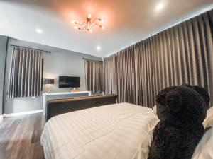 - une chambre avec un grand lit et un lustre dans l'établissement Black Bear House Resort & Onsen, à Chiang Dao
