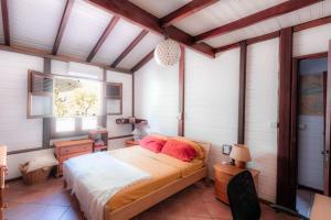 ein Schlafzimmer mit einem Bett mit roten Kissen in der Unterkunft Villa - Bleu Mer Caraïbes in Case-Pilote