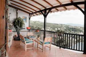 Un patio con sillas y una mesa en el balcón. en Villa - Bleu Mer Caraïbes, en Case-Pilote