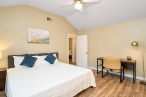 a bedroom with a bed and a desk and a chair at Luxury Retreat - Pool - Game Lounge - BBQ & Patio in San Antonio +23 photos