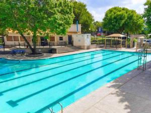Luxury Retreat - Pool - Game Lounge - BBQ & Patio في سان انطونيو: مسبح ازرق كبير مع اشجار في الخلفية