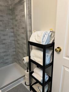 La salle de bains est pourvue d'un sèche-serviettes noir et de serviettes. dans l'établissement 2BR 1BA Guest Suite - Free Parking - Central Location w/ Mountain-View, à Vancouver