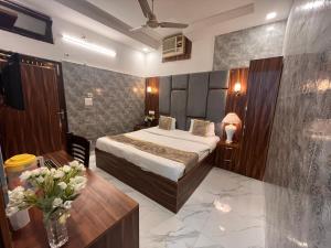 德拉敦Hotel Embassy的配有床和鲜花桌的酒店客房