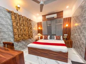 a bedroom with a bed and a desk in it at Hotel Embassy in Dehradun