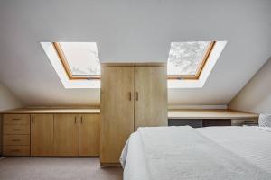 a bedroom with a bed and two skylights at Le Arc Manor House in Franschhoek