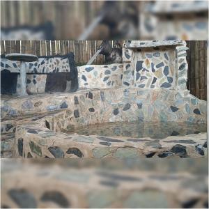 a stone bench with a fountain in a park at Preciosa cabaña en plena naturaleza con jaccuzi in Dosquebradas