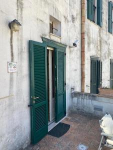 a door with green shutters on a building at Residence Le Vie Del Mosto in Matera