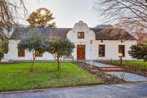 a white house with a tree in front of it at Le Arc Manor House in Franschhoek