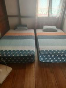 two beds sitting next to each other in a room at Kutnalek Surf Camp Siberut in Masokut