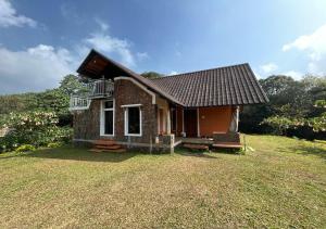 a small brick house on a grass field at Vagamon Heights in Vagamon