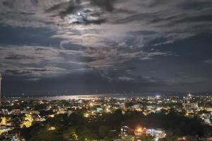 a city at night with the moon in the sky at Davao City Serenity on Seventeenth One-Bedroom Condo beside Shopping Malls with Seaview and City view in Davao City