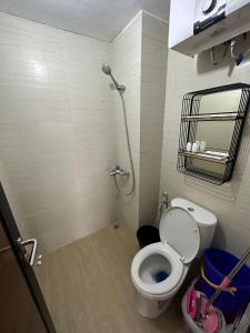 een kleine badkamer met een toilet en een douche bij Gateway Pasteur Apartment by RumahKu in Bandung