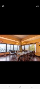 a large dining room with tables and windows at Little Singamari Home Stay in Darjeeling