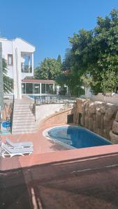 a swimming pool in front of a building with stairs at London House Hotel in Kemer