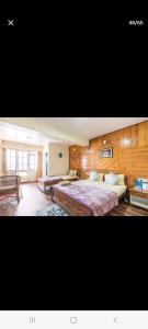 a large bedroom with two beds and a bench at Little Singamari Home Stay in Darjeeling