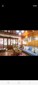 a living room with a blue couch and a table at Little Singamari Home Stay in Darjeeling