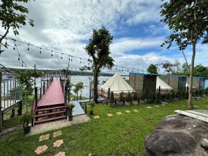 a park with a ramp and a tent next to the water at ปลายเขื่อนแคมป์ปิ้ง in Sirindhorn