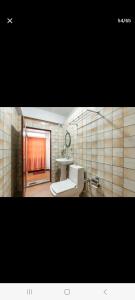 uma casa de banho com um lavatório e um WC num quarto em Little Singamari Home Stay em Darjeeling