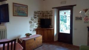 een woonkamer met een tv en een raam bij BeB Il Poderino Family Room in Dicomano
