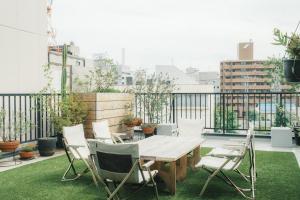 a patio with a wooden table and chairs on a balcony at Okazaki Micro Hotel ANGLE in Okazaki