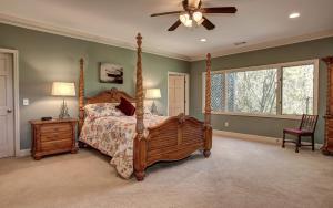a bedroom with a canopy bed and a ceiling fan at Mountain Memories - Viking gas range GE double ovenwarmer Lake views in Marblehill