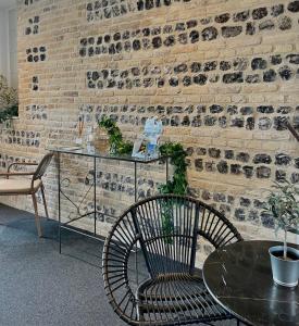 a table and a chair in a room with a brick wall at LA TOUR AUX CRABES près de la plage in Dieppe