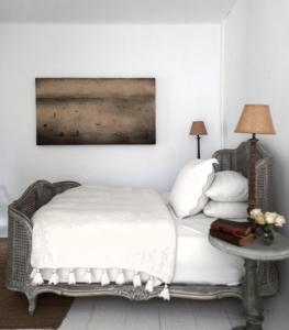 a white bedroom with a bed and a table at The White House Homestay in Pantai Cenang