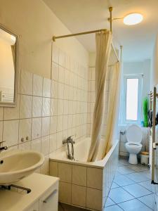 ein Badezimmer mit einer Badewanne, einem Waschbecken und einem WC in der Unterkunft Geräumige Wohnung im Herzen Kassels in Kassel