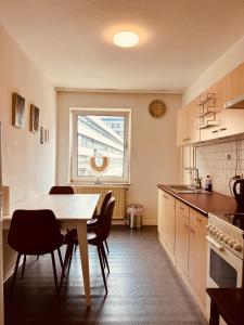 eine Küche mit einem Tisch und Stühlen sowie einem Fenster in der Unterkunft Geräumige Wohnung im Herzen Kassels in Kassel
