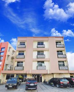 a building with cars parked in front of it at Hotel Wisata Samosir By Helocus in Pangururan