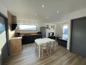 a kitchen and dining room with a white table and chairs at Appartement climatisé in Charmes