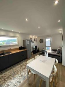 a kitchen and living room with a white table and chairs at Appartement climatisé in Charmes